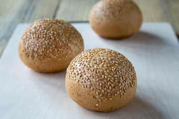 three rolls of sesame seeds on a rustic table