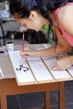 Woman writing with a paintbrush