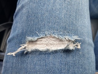 fashion background leg of woman in blue jean pants with torn