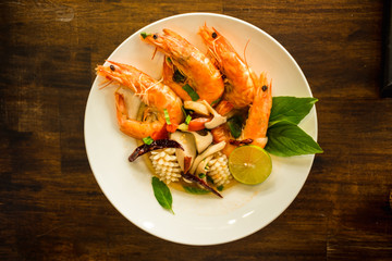 delicious thailand food fried shrimp and squid cook herb in dish wooden table background