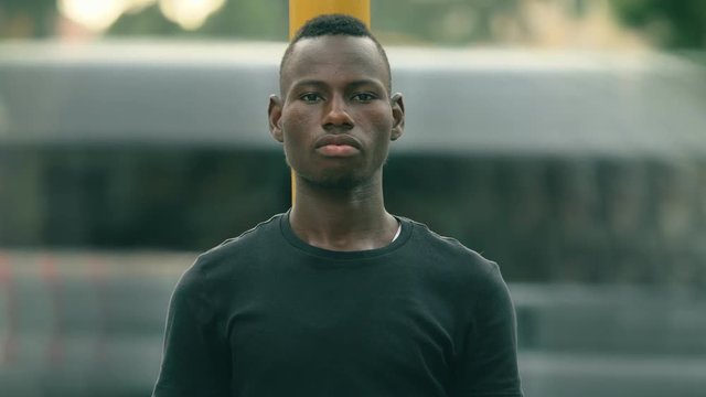 Confident proud American African youn man in the street looking at camera