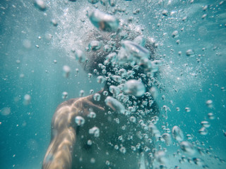 Fototapeta na wymiar Attractive young man submerged in pool with many bubbles