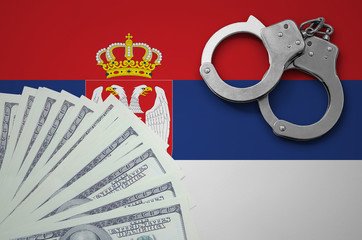 Serbia flag  with handcuffs and a bundle of dollars. The concept of illegal banking operations in...