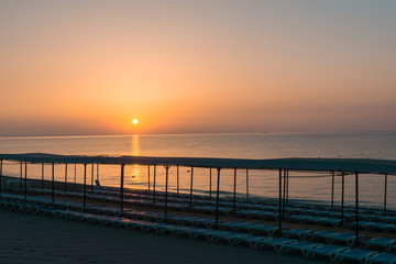 Fototapeta na wymiar Beach in morning with sun loungers