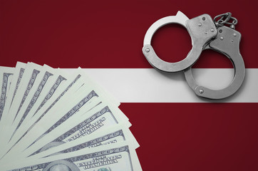 Latvia flag  with handcuffs and a bundle of dollars. The concept of illegal banking operations in...