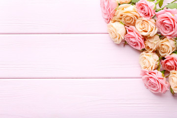Bouquet of roses on pink wooden table