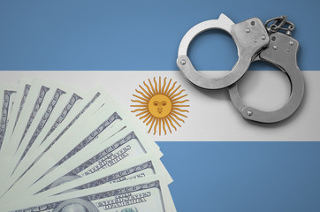 Argentina flag  with handcuffs and a bundle of dollars. The concept of illegal banking operations...
