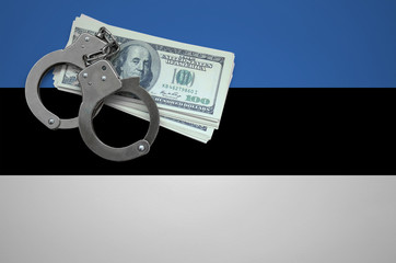 Estonia flag  with handcuffs and a bundle of dollars. The concept of breaking the law and thieves...