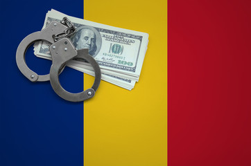 Romania flag  with handcuffs and a bundle of dollars. The concept of breaking the law and thieves...