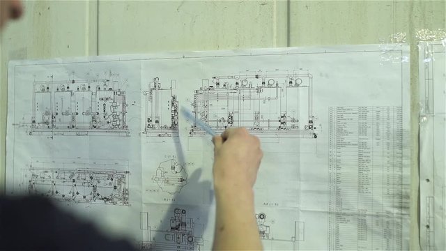 The engineer studies the scheme of the water treatment plant