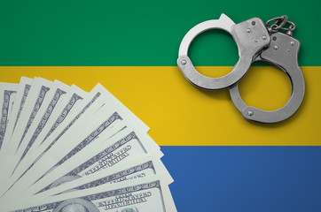 Gabon flag  with handcuffs and a bundle of dollars. The concept of illegal banking operations in US...