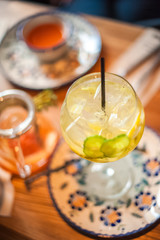 Summer cocktail in a large glass with lemon, cucumber. Summer sangria on the table in a cafe