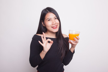 Young Asian woman show OK drink orange juice.