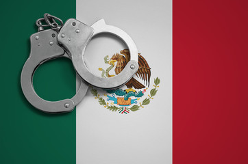 Mexico flag  and police handcuffs. The concept of crime and offenses in the country