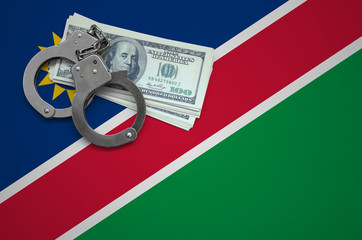 Namibia flag  with handcuffs and a bundle of dollars. The concept of breaking the law and thieves...