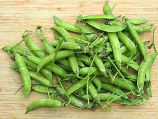 Gesunde Ernährung: Erbsenschoten auf Holzbrett