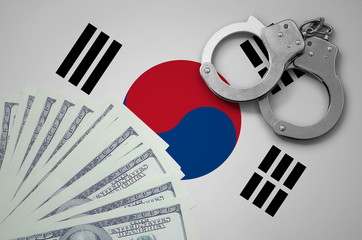 South Korea flag  with handcuffs and a bundle of dollars. The concept of illegal banking operations...