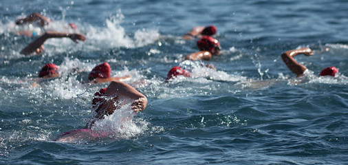 Group people in wetsuit swimming at triathlon