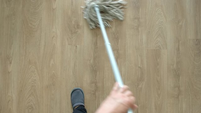 TOP VIEW: Young adult man washing a floor by mop - Close Up