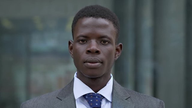 Serious confident black american young business man staring at camera- outdoor
