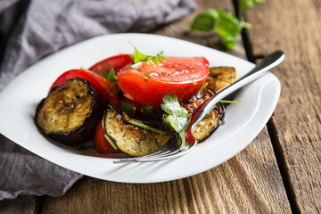 Salad of baked eggplants and fresh tomatoes with parsley