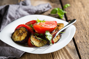Salad of baked eggplants and fresh tomatoes with parsley