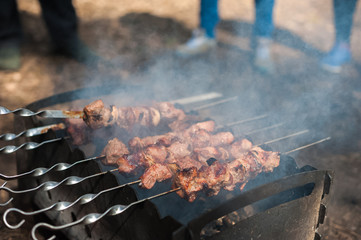 Natural texture. Shish kebab on the grill on skewers in the smoke. Fry meat with onion on skewers