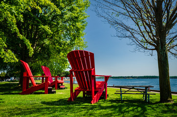 Three giant red adirondack chairs at Brockville's St. Lawrence River waterfront,