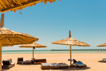 sun beds under parasols at seaside view