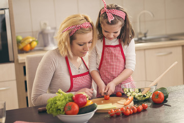 Little girl cutting cherry tomato