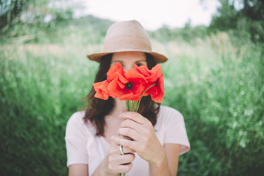 Woman holding a bouquet of red poppies in spring
