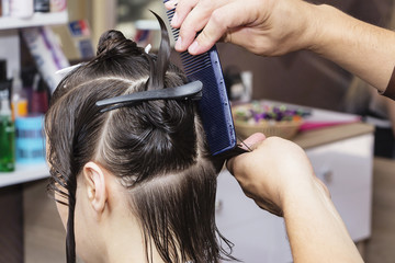 Naklejka premium stylist hairdresser in barber shop doing haircut closeup.
