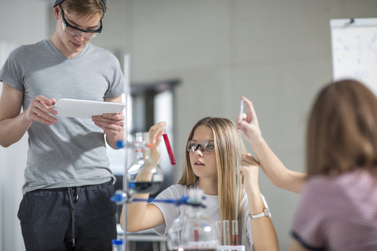 Students in science class with test tubes and tablet