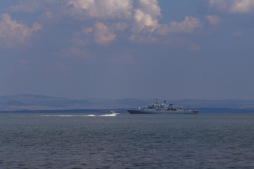 a warship floats in the water against the background of a dramatic sky. a naval vessel is taken to...