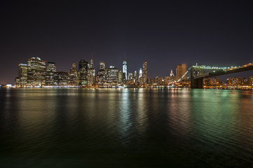 Colorful city lights at night from Brooklyn Bridge in New York City