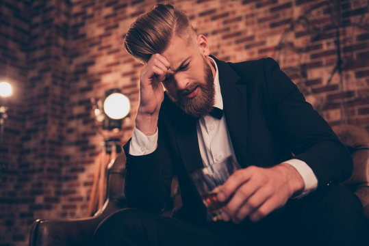 Single bachelor freelancer entrepreneur misfortune mood people concept. Sad upset unhappy virile poor disappointed guy with modern hairdo drinking rum because lost all his money when gambling