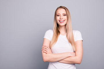 Obraz premium Portrait of young caucasian, charming, attractive gorgeous cute smiling girl wearing casual white t-shirt with folded hands Isolated over grey background, copy space