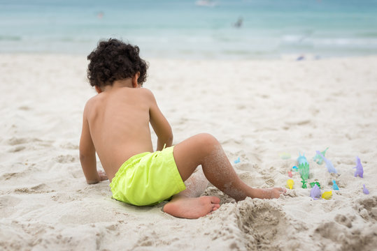 Little boy playing with toys on the beach. Travel