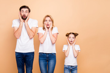 Young family with daughter, parents spouses and their little daughter placing hands to thier faces to show surprising, standing in order to hierarchy