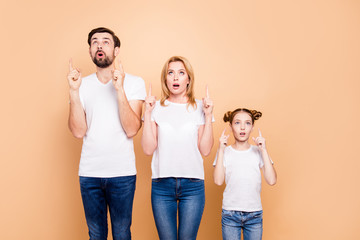 Bearded father, blonde mother and their little daughter standing straight and pointing up with...