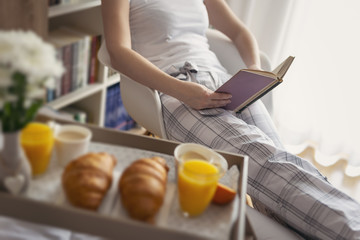 Woman reading a book before breakfast