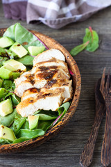 Green lunch bowl with grilled chicken, avocado and eggs. Healthy and dietary food. Space for text.