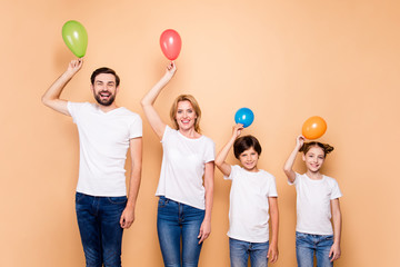 Young smiling family, bearded father, blonde mother, boy and girl wearing blue jeans and white...