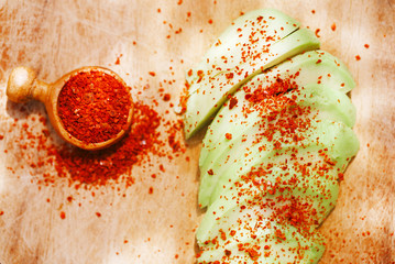 avocado slices sprinkled with aleppo pepper on wood