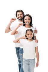 Foto auf Acrylglas Zahnärzte portrait of smiling family in white shirts with toothbrushes isolated on white  © LIGHTFIELD STUDIOS