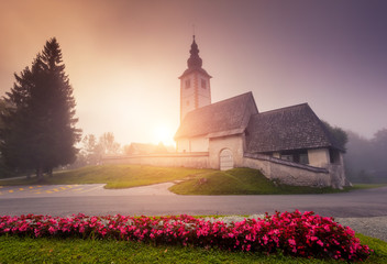 Misty view of the church Sv. John the Baptist. Location place Triglav national park, Bohinj valley.