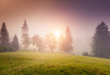 Misty view of the church Sv. John the Baptist. Location place Triglav national park, Bohinj valley.