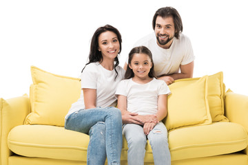 portrait of cheerful family in white shirts on yellow sofa isolated on white
