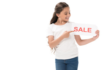 portrait of smiling kid pointing at sale banner in hand isolated on white