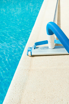 Manual Swimming Pool Vacuum Cleaner on Stone Deck. Bright Summer Sunny Day. Maintenance Cleaning Service Concept. Poster Banner with Copy Space